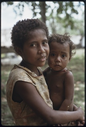 Girl holds young child on her lap