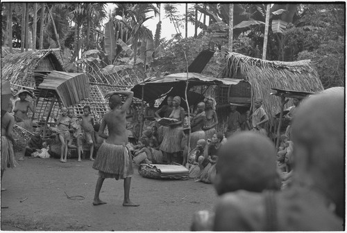 Mortuary ceremony, Omarakana: mourning women and children gathered for ritual exchange of banana leaf bundles