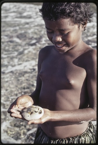 Fishing: girl holds a small puffer fish near Wawela village