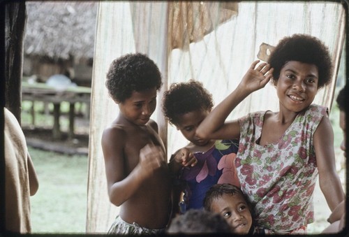 Adolescent girl and other children in the shade