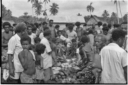 Mortuary ceremony: people with piles of yams, taro, and betel nut to be distributed to mourners