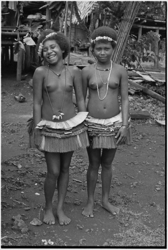 Friendship: adolescent girls in short fiber skirts, necklaces and garlands, girl (l) wears mourning necklace