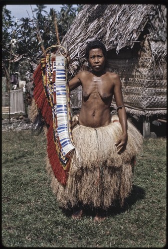 Woman displays decorated fiber skirt valuable, she wears two-tiered long fiber skirt