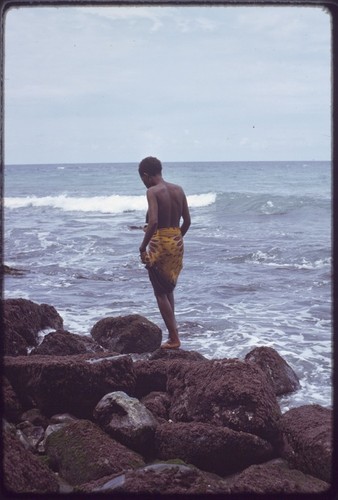 Kairiru: woman on rocky coastline