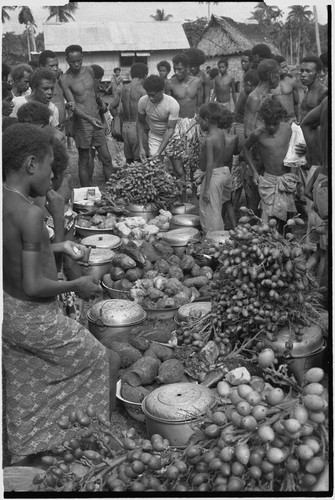 Mortuary ceremony: men with piles of yams, taro, and betel nut to be distributed to mourners