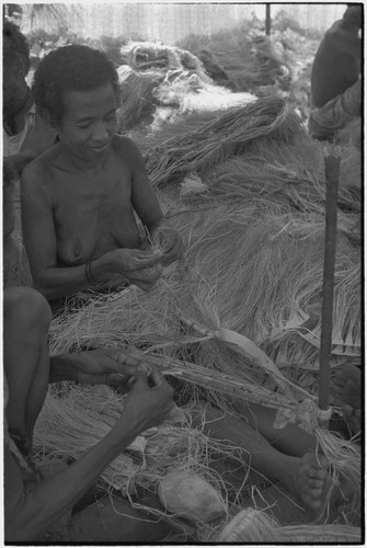 Mortuary ceremony: woman weaves long fiber skirt for ritual exchange