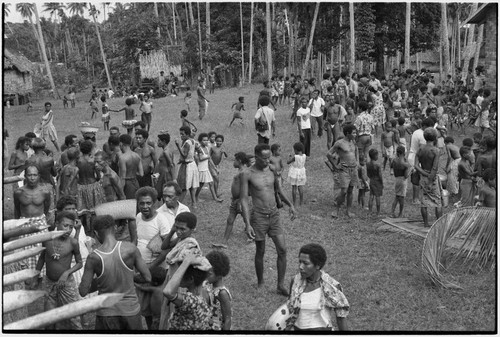 Mortuary ceremony: large gathering of people in village clearing