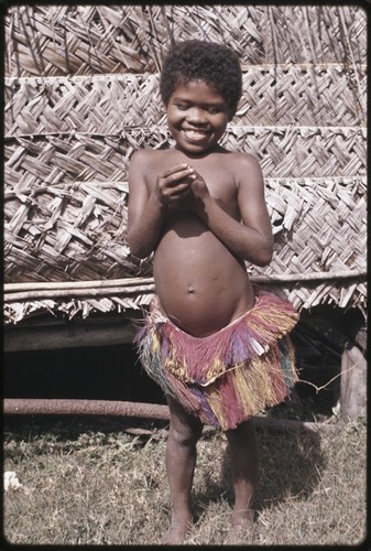 Smiling girl wearing a colorful banana-fiber skirt