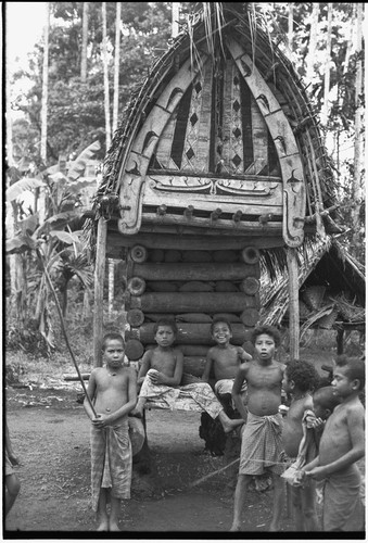 Yam house of the chief of Omarakana has a decorated facade and is full of yams, boys hang out