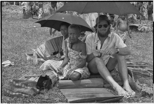 Mortuary ceremony: Edwin Hutchins and women side in shade under umbrellas