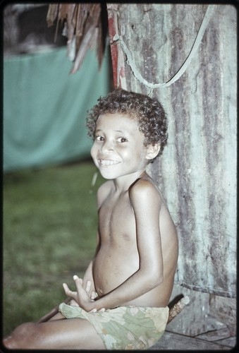 Smiling boy beside a house