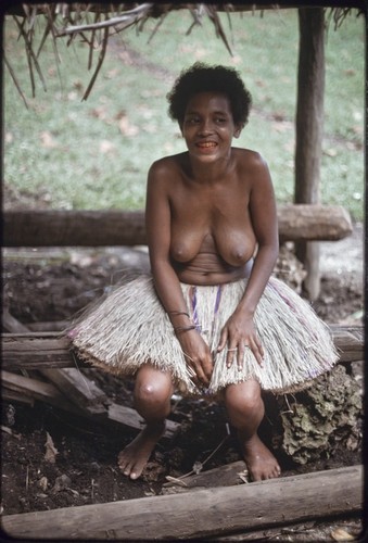 Smiling women wearing fiber skirt, her teeth stained red from betel nut