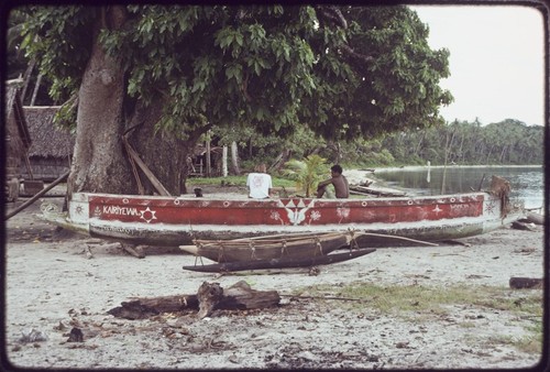 Canoes on the beach at Wawela village, including red-painted kula canoe with "Kairiyewa" written on the side