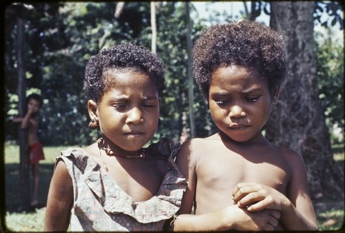 Children, girl (l) wears turtle shell earrings and shell necklace