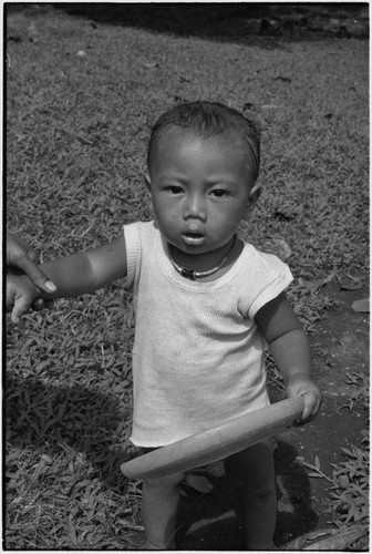 Infant holds a flying disc