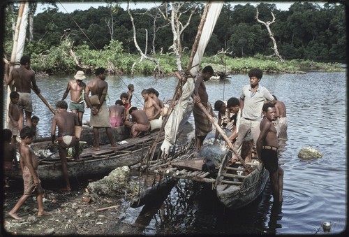 Fishing: people gather to get fish displayed on canoes that have just returned from overnight fishing