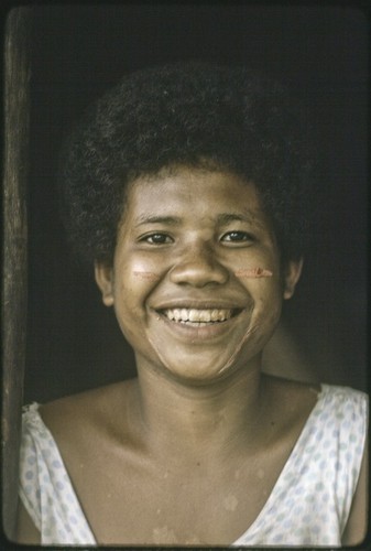 Smiling young woman with dashes of betel nut paste on her cheeks