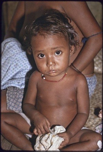 Young child wearing shell necklace