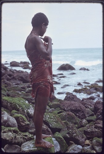 Kairiru: woman on rocky coastline