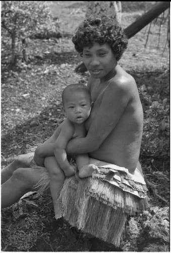 Young woman in short fiber skirt, holding infant