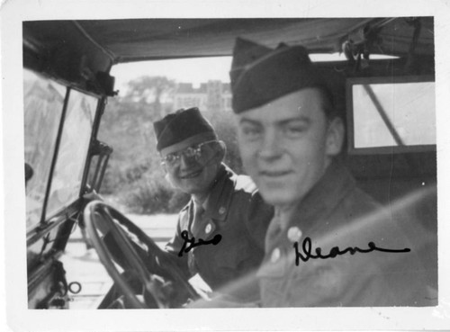 [Two men in military uniform in military vehicle]