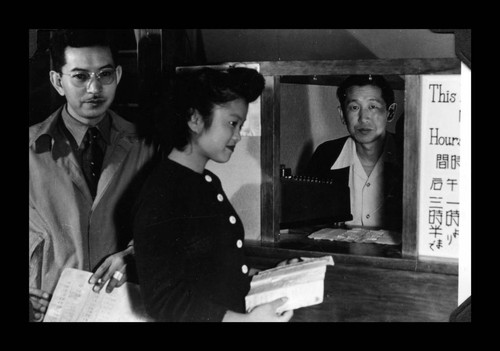 Henry Tsuno and Helen Akahoshi in the cashier office, Amache Co-op