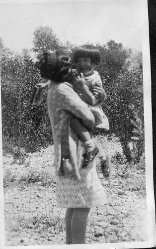 [Woman and child in apple orchard]