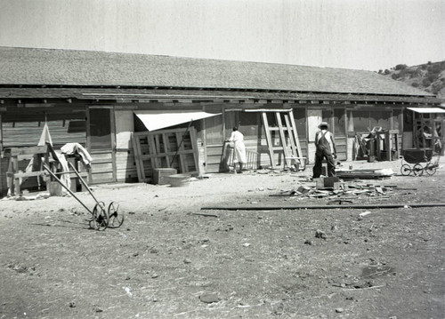 Woman and man working outside a wooden structure