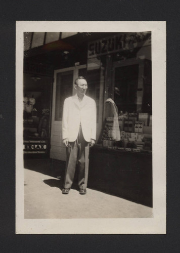 Photograph of Yoneo Suzuki in front of Suzuki Pharmacy Store