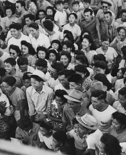 [Incarcerees watching outdoor musical performance at Manzanar incarceration camp]