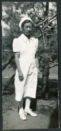 Photograph of Yone Akite, R.N., posing in front of a tree at Manzanar