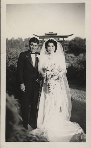 Bride and groom in front of Japanese Temple gate