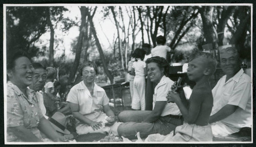 Photograph of a laughing group of people at a Manzanar hospital staff picnic