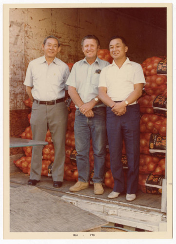 Minoru Frank Saito standing next to bags of onions