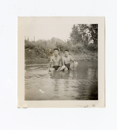 Young men sitting in a lake