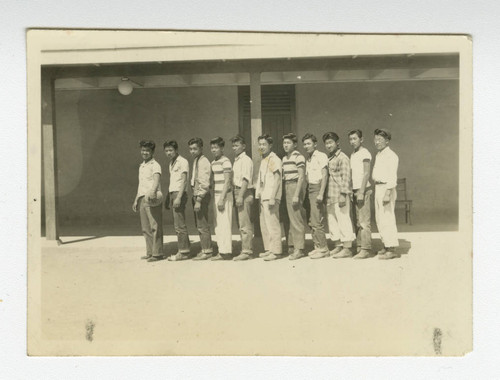 Nisei men's basketball team standing in front of barrack