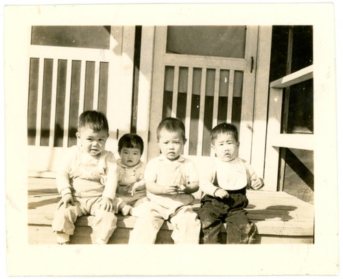 Babies sitting on barrack stairs