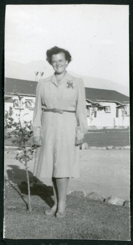 Photograph of Martha Shoaf in front of staff housing at Manzanar