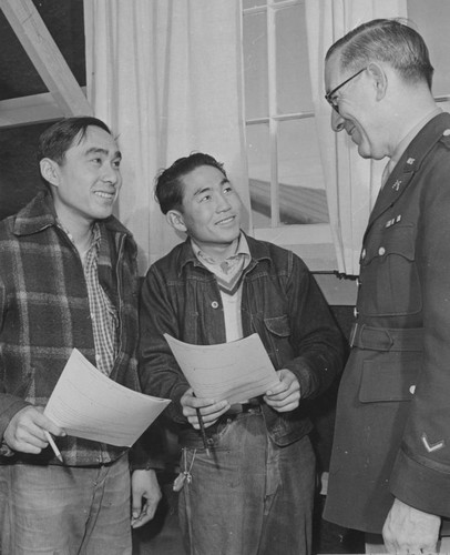 [Captain William S. Fairchild discussing the army with two young Nisei volunteers]