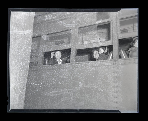 Three women from Terminal Island sitting inside a train car on "evacuation" night