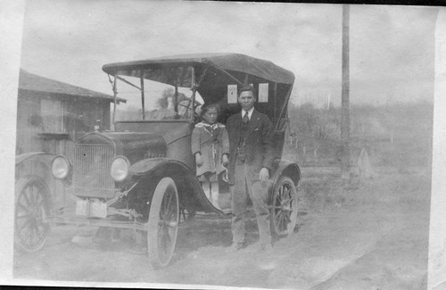 [Man and child near car]