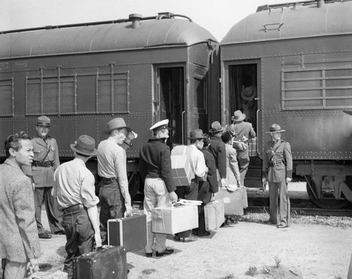 Indonesians boarding a train in San Francisco for the immigration detention facility at Crystal City, Texas