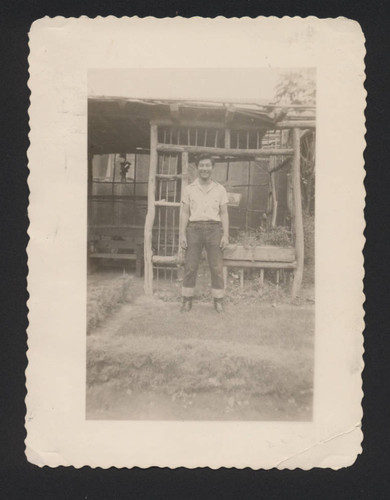 Man standing in wide stance in front of wooden garden bower