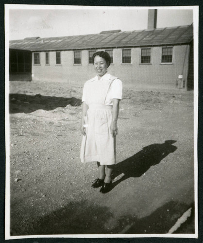 Photograph of a hospital nurse in front of a building