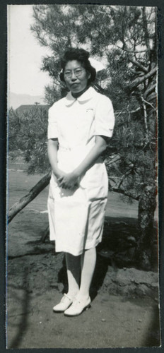 Photograph of a nurse posing in front of a tree at Manzanar