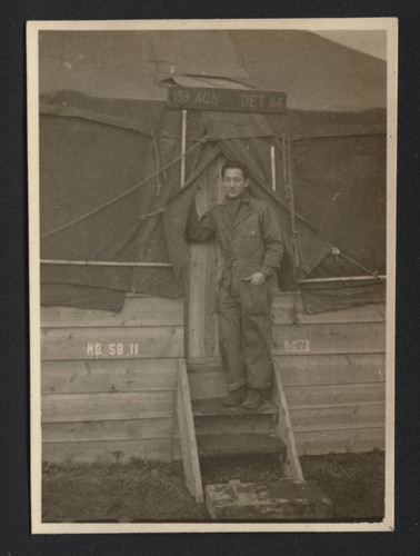 George Oki standing on stairs of military tent at Itazuke Air Force Base