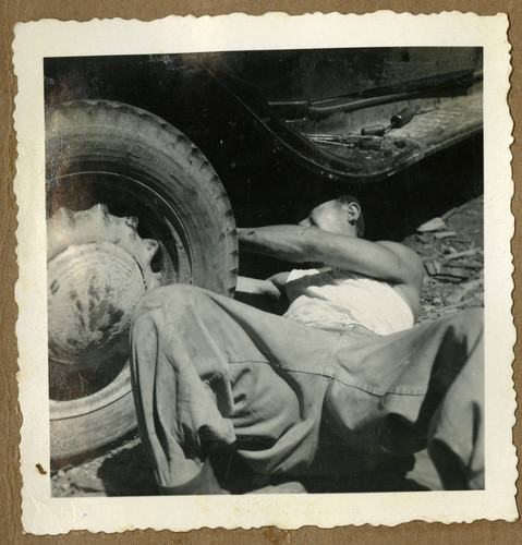 Japanese Peruvian man fixing a car