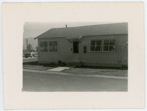 Photograph of Manzanar staff housing with dog in front