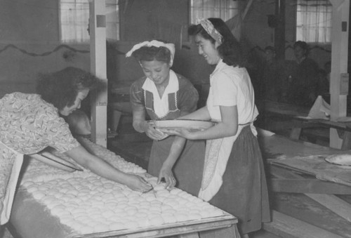 Women arranging mochi on a table