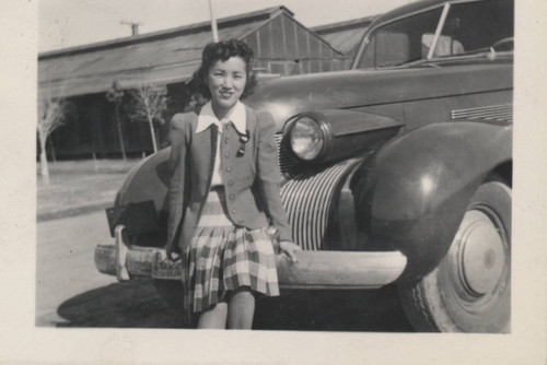 Sue Hashimoto sits on the bumper of a car at Poston incarceration camp